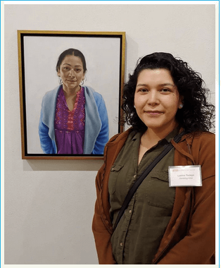 Luanne Redeye in front of a portrait she painted