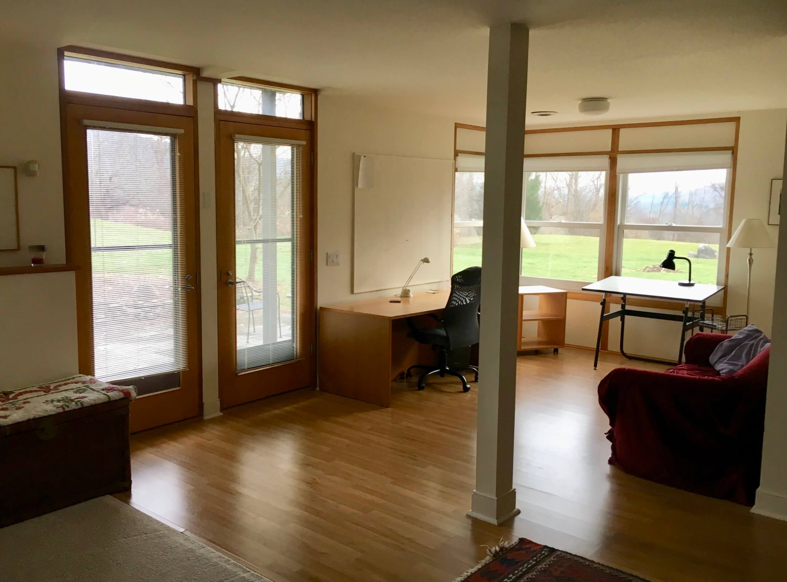 visual arts studio with vaulted ceiling, large windows, and a vinyl tile floor